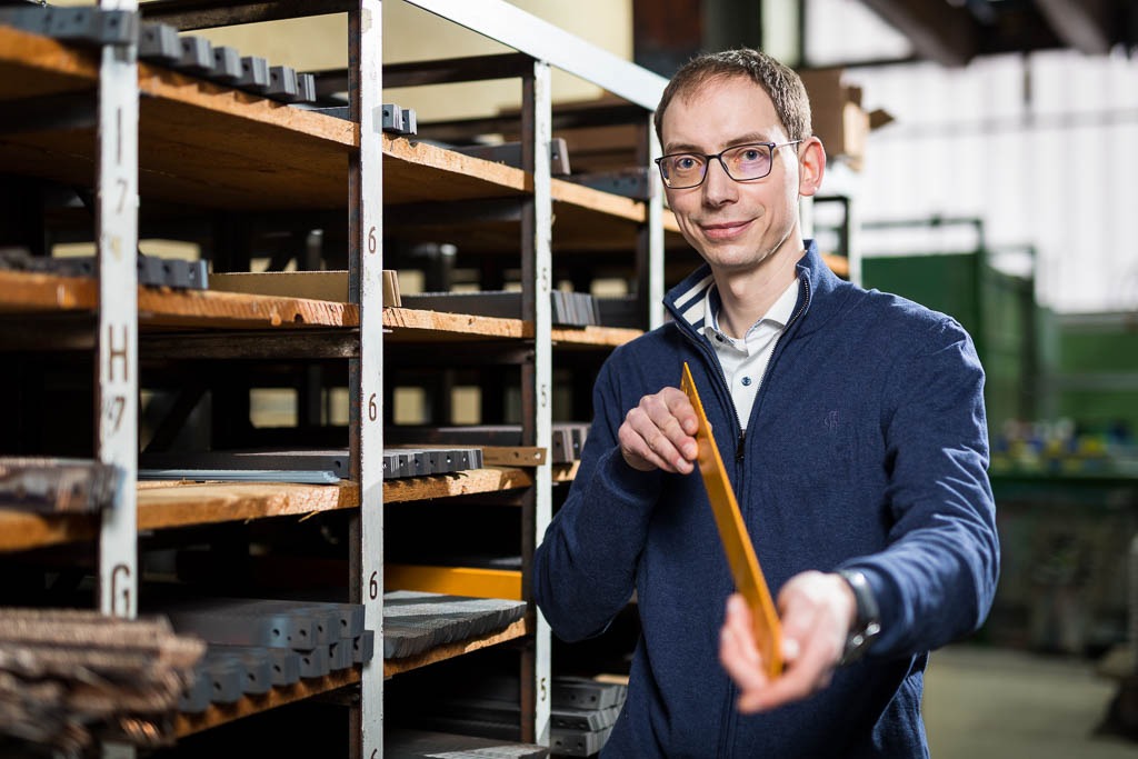Mitarbeiter präsentiert Metallsägeblatt im Lager. Mitarbeiter präsentiert Metallsägeblatt im Lager.