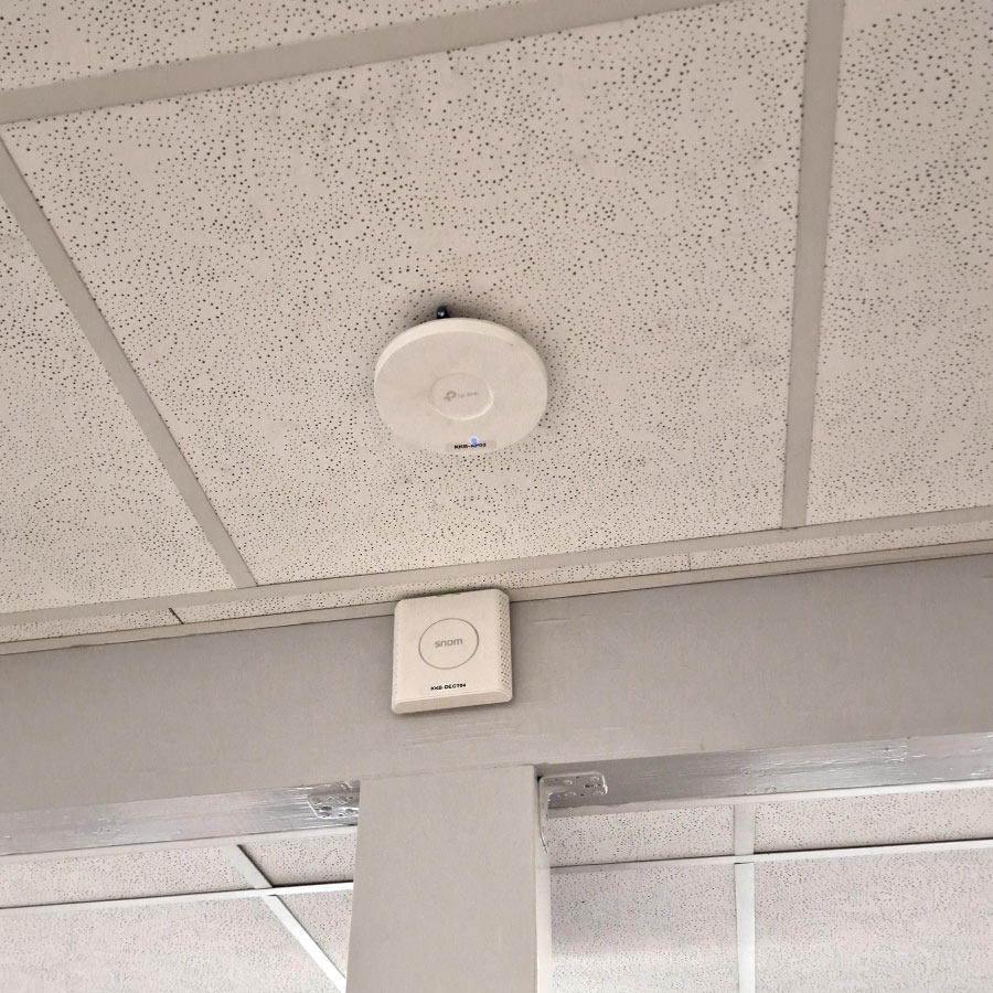 WLAN-Access-Point und Telefonmodul an einer abgehängten Decke montiert. WLAN-Access-Point und Telefonmodul an einer abgehängten Decke montiert.